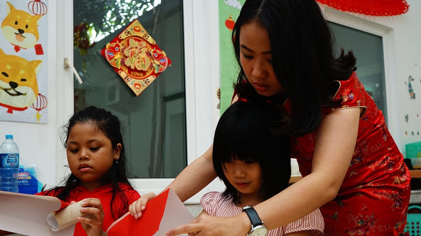 Guru Kiddles mendampingi seorang anak menulis karakter Mandarin
