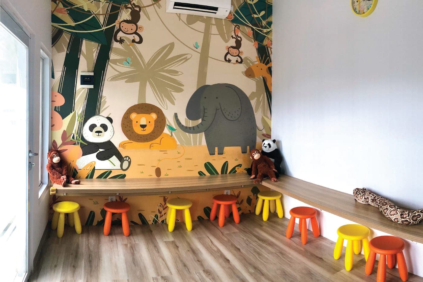Ruang kelas anak di Kiddles dengan mural hewan dan kursi warna-warni