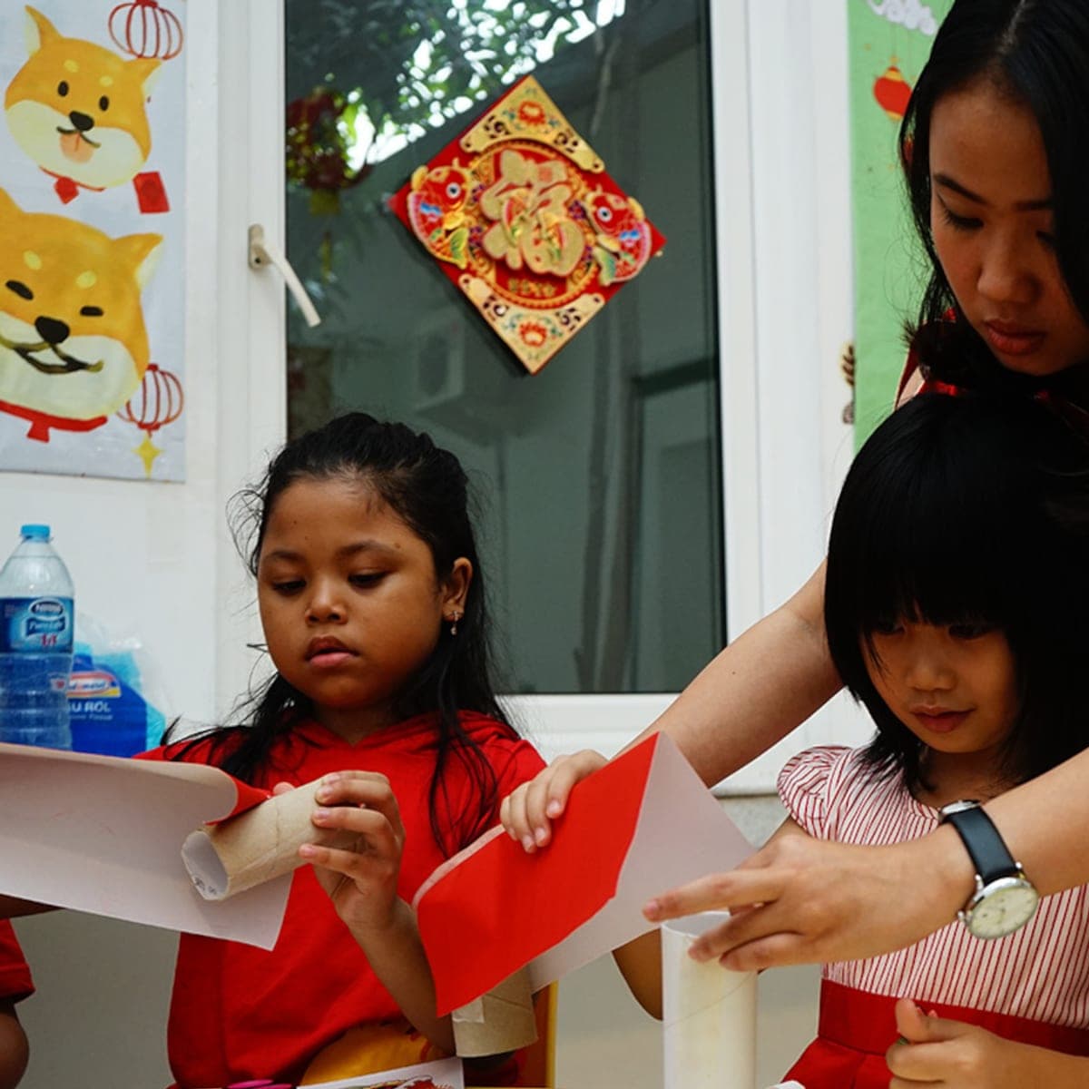Tangan anak menulis karakter Mandarin di buku kotak tian zi ge