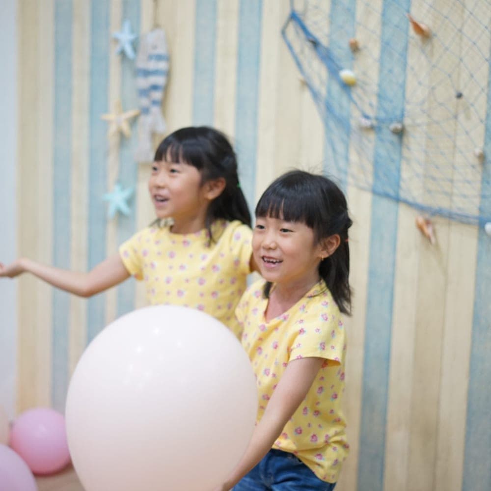 Dua murid Kiddles tertawa bersama saat kegiatan kelas