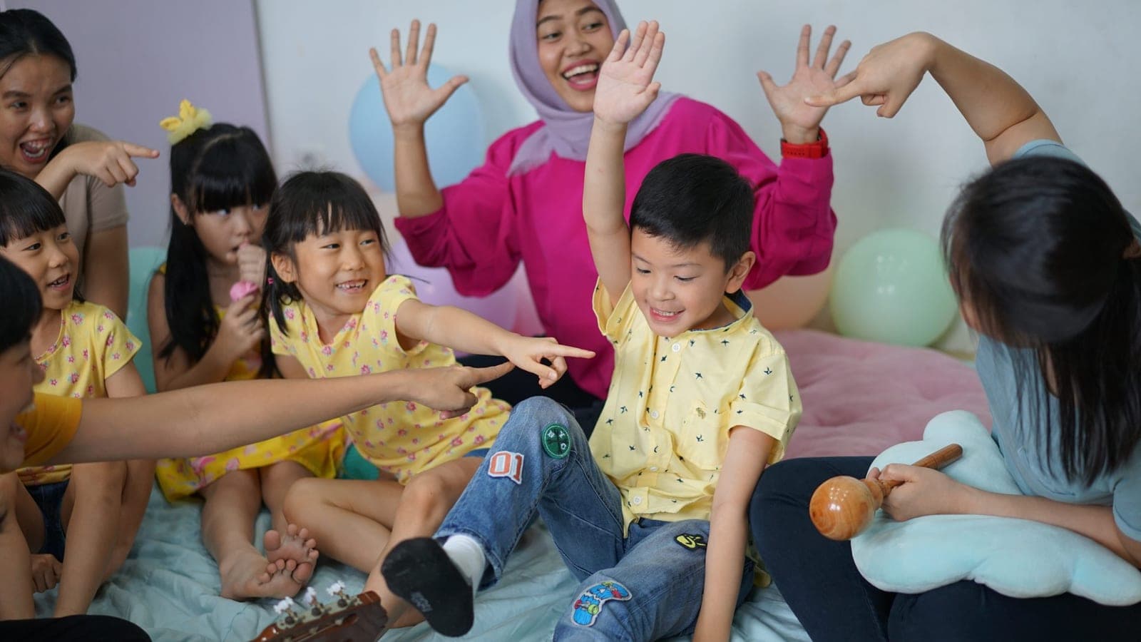 Guru dan murid Kiddles tertawa bersama saat kegiatan kelas